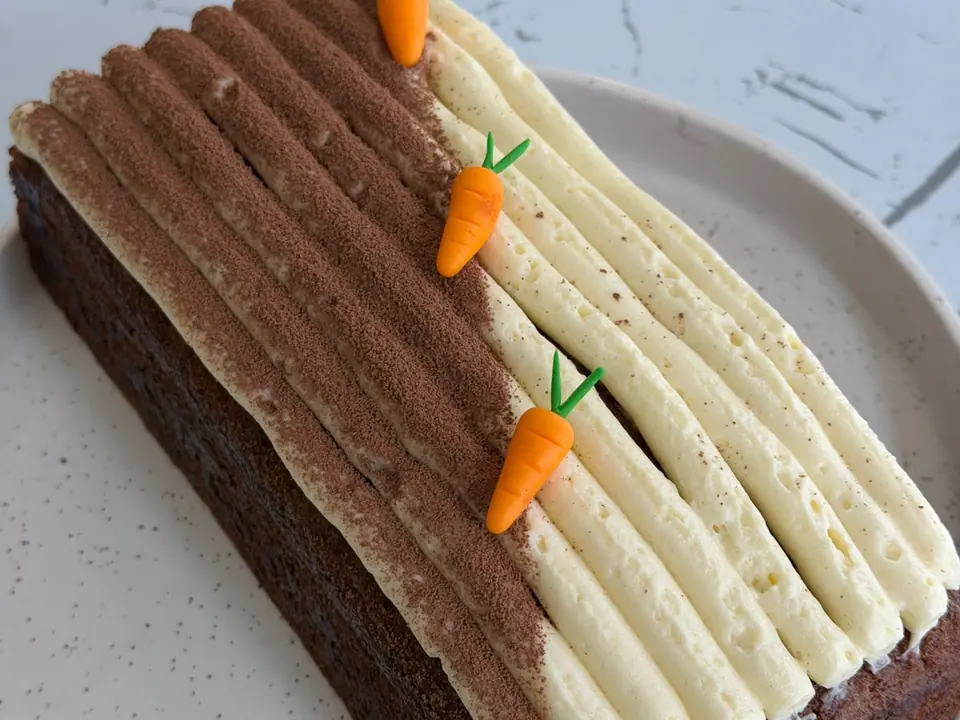 A Minori carrot cake loaf with cream cheese frosting and piped carrots